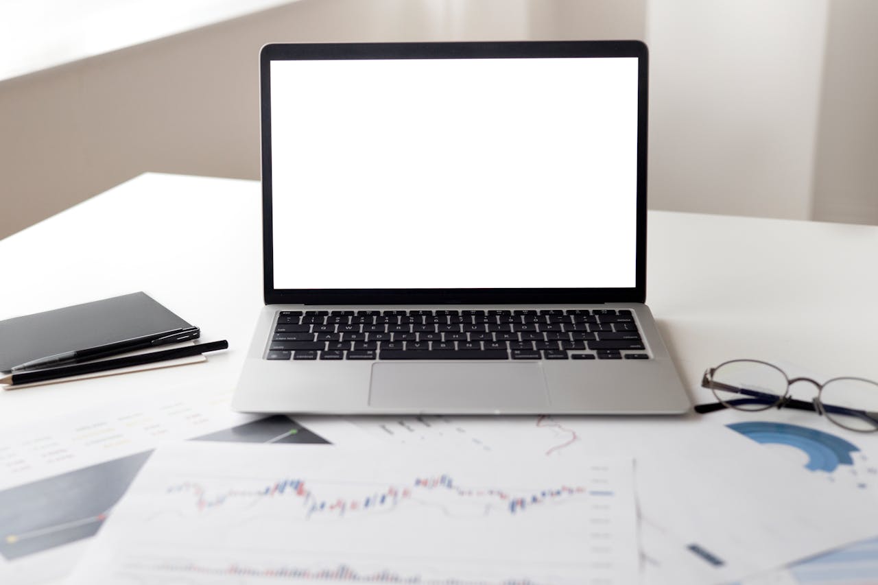 digital Open laptop with financial documents on a desk, ideal for business and technology themes.